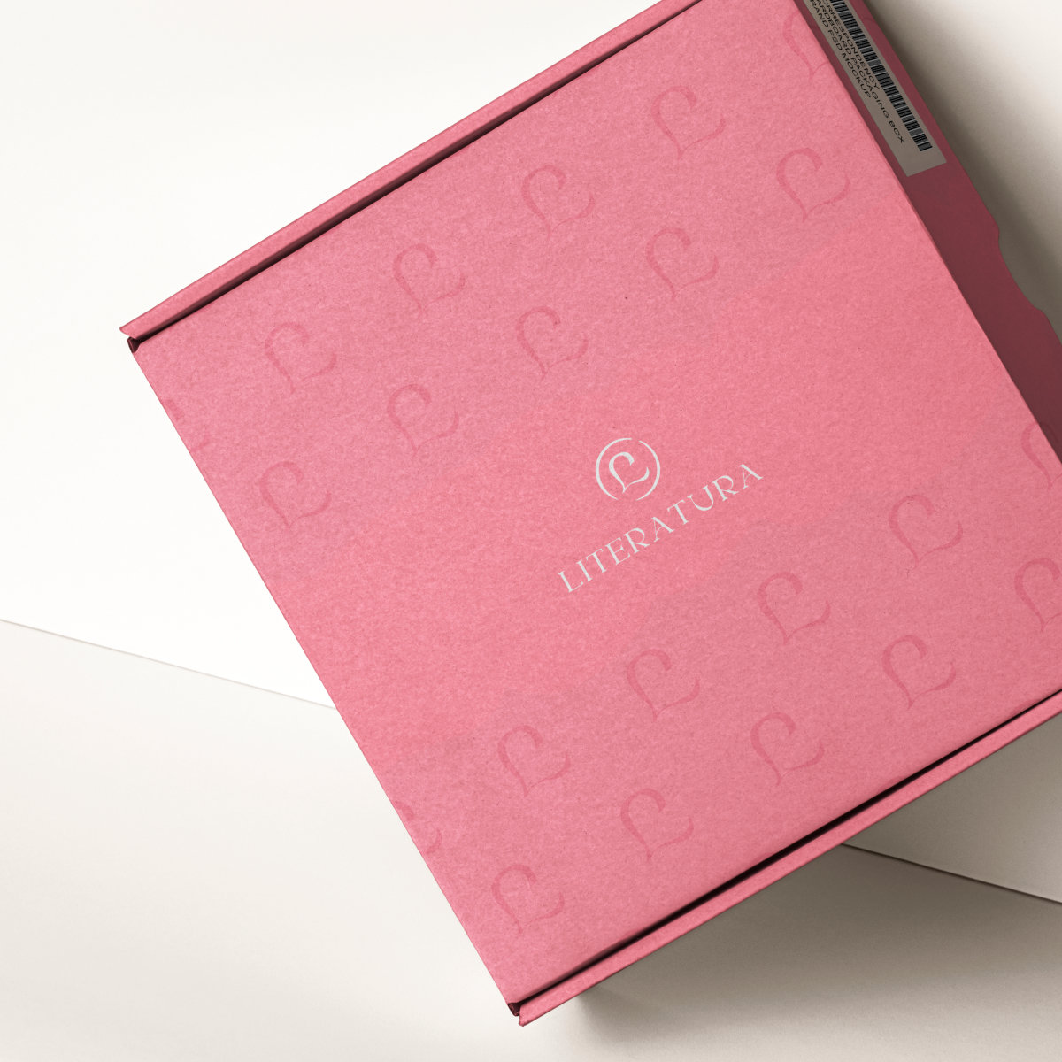 Boite en carton rose avec le logo de Literatura en blanc.