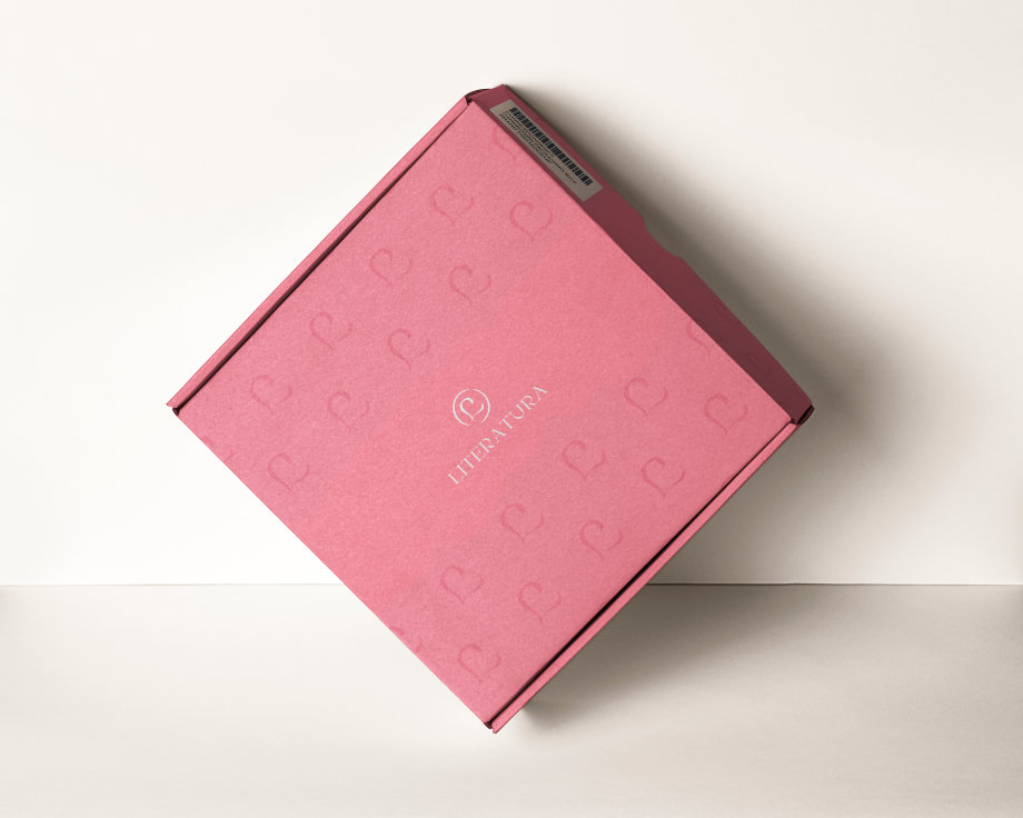 Boîte en carton rose avec le logo de Literatura en blanc.