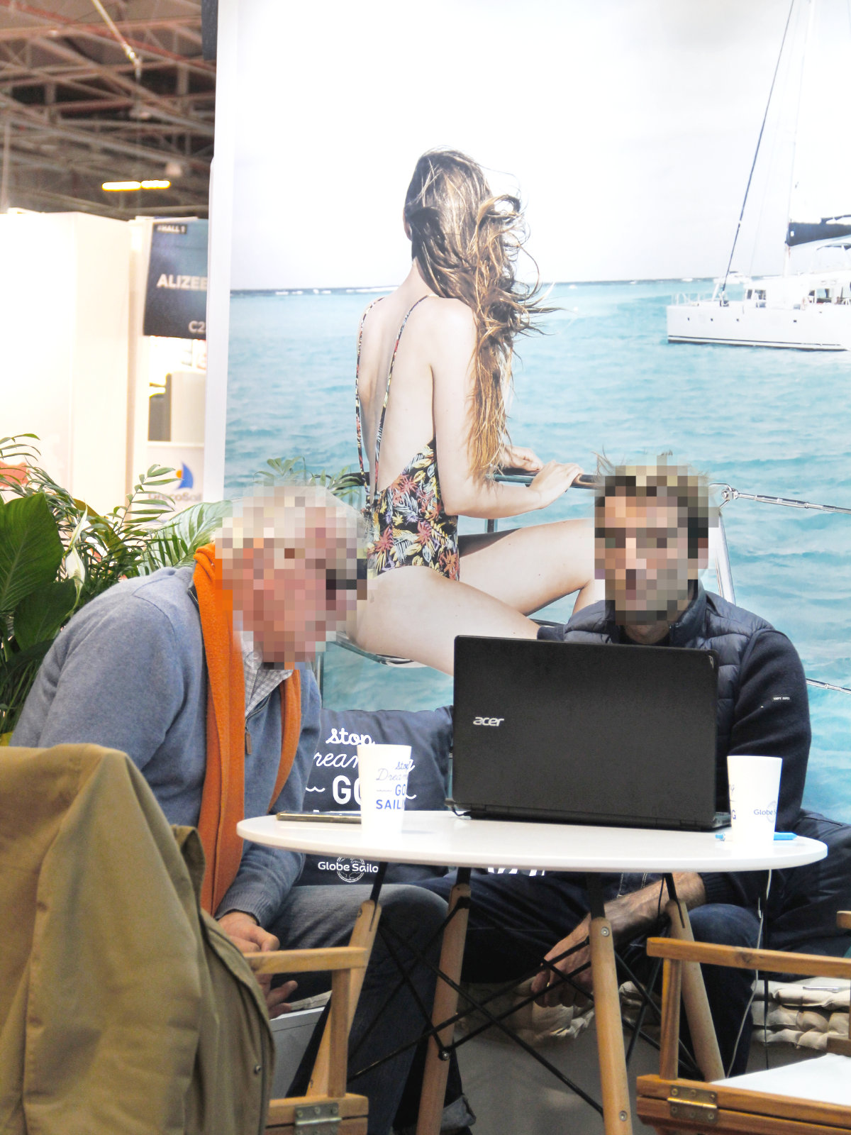 Coin gauche du stand de GlobeSailor. Un conseiller guide personnellement la réservation d'un client.