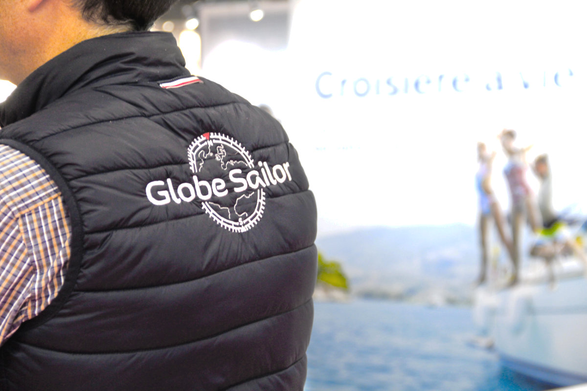 Close-up of a GlobeSailor down jacket logo seen from behind. The stand appears in the background.
